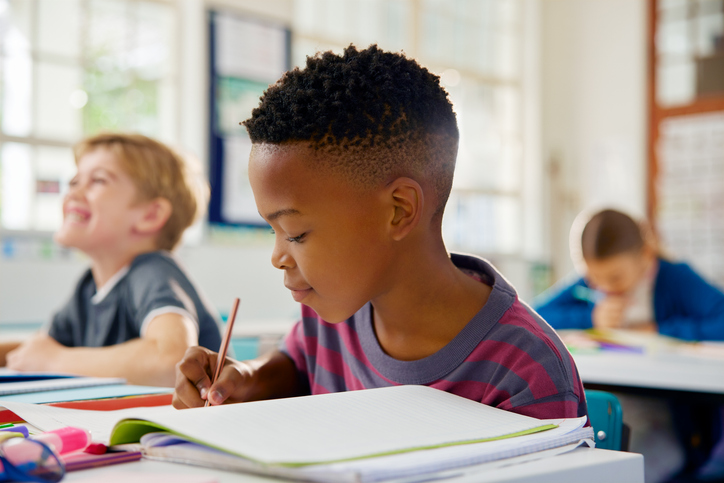 Male student writing in notebook