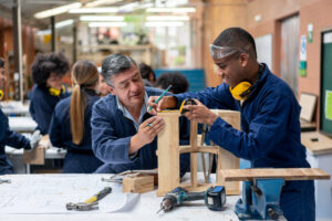 Woodworking class teacher helping student